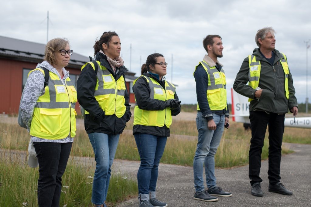 Elena (OMS), Leila (HZDR), Joan Marie (HZDR), Juha (UEF), and Panu (SYKE) watching the helicopter take-off with the VTEM™ sensor attached